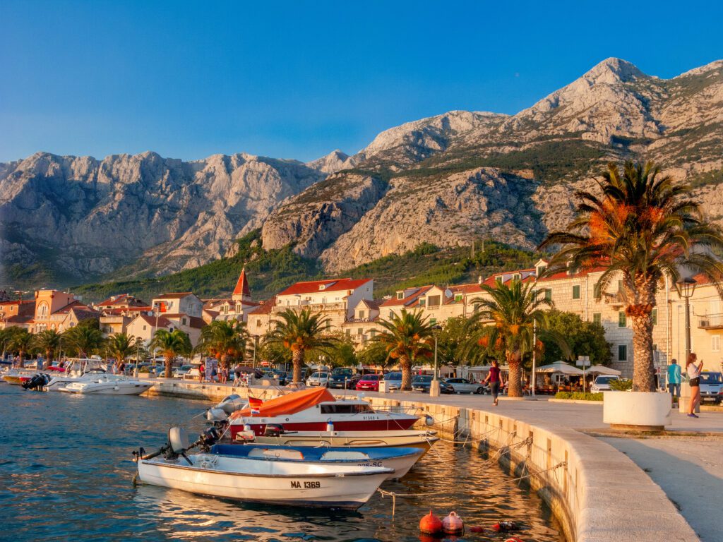 Croatia sunset in Split setting over the harbor lined with palm trees