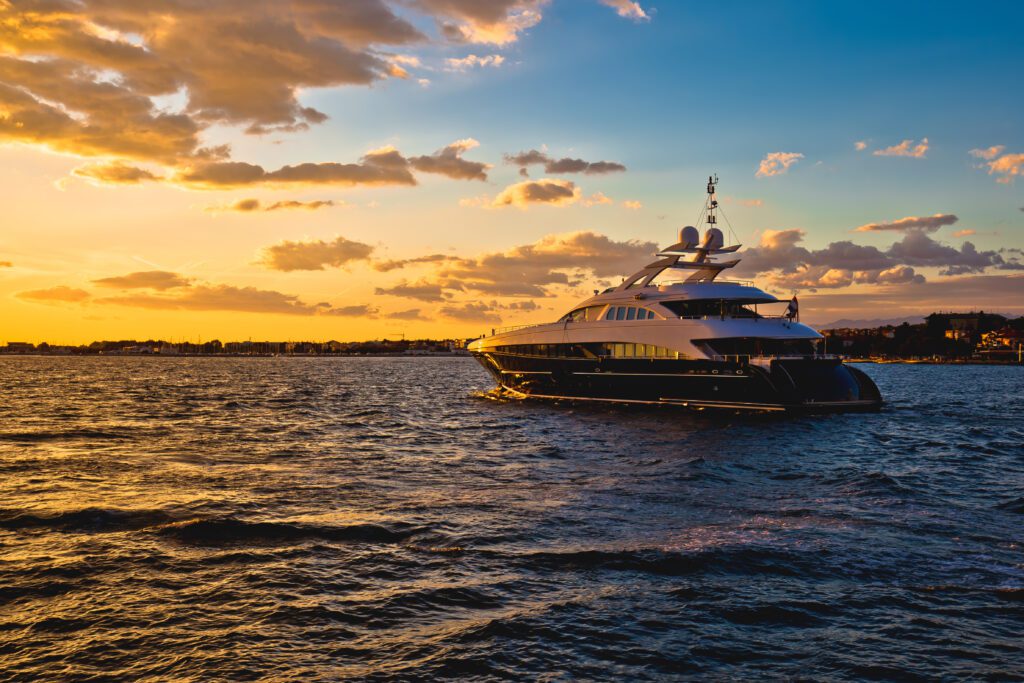 Croatia sunset in the Adriatic Sea as a private yatch sails on the sea towards it