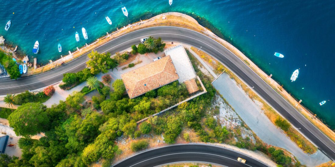 cars driving in Croatia on a seaside road with the ocean in view